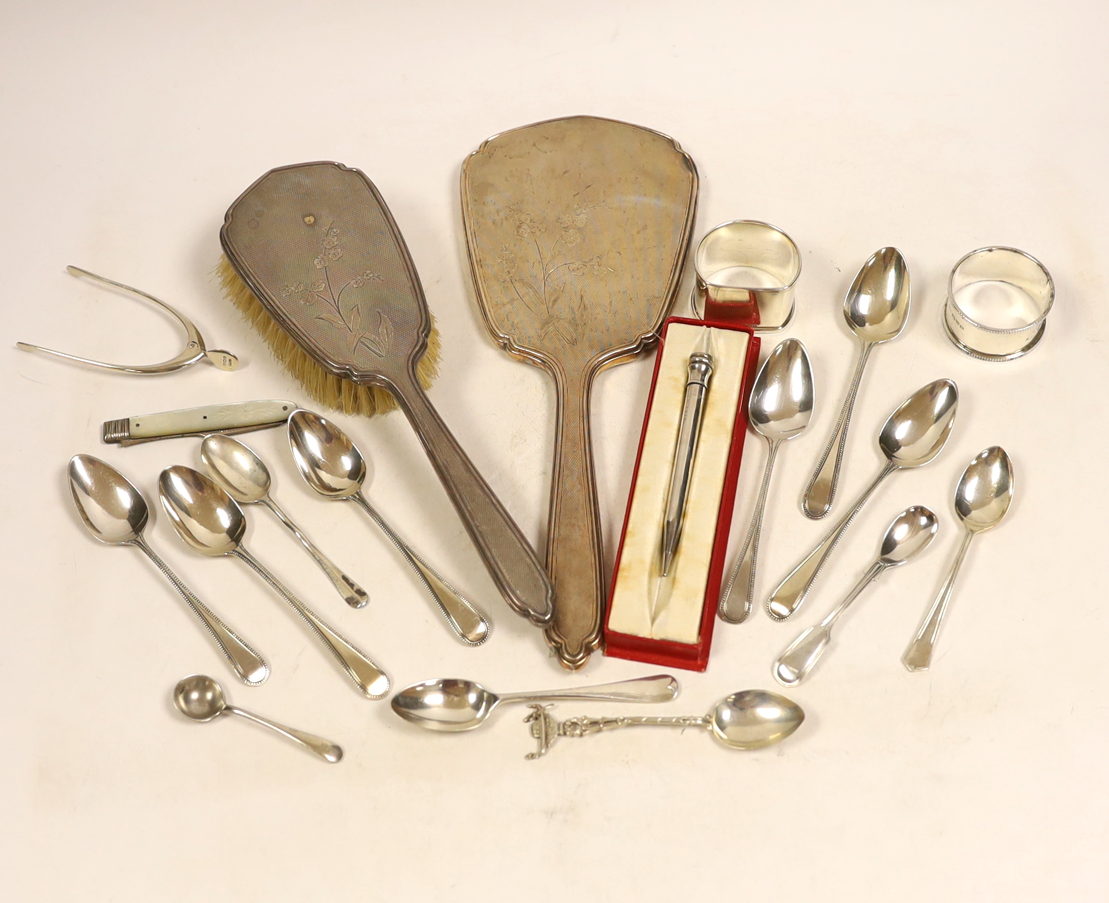 A silver mounted hand mirror and hair brush and sundry small silver including teaspoons, Georgian travelling fork, wishbone sugar nips, napkin rings and pencil.
